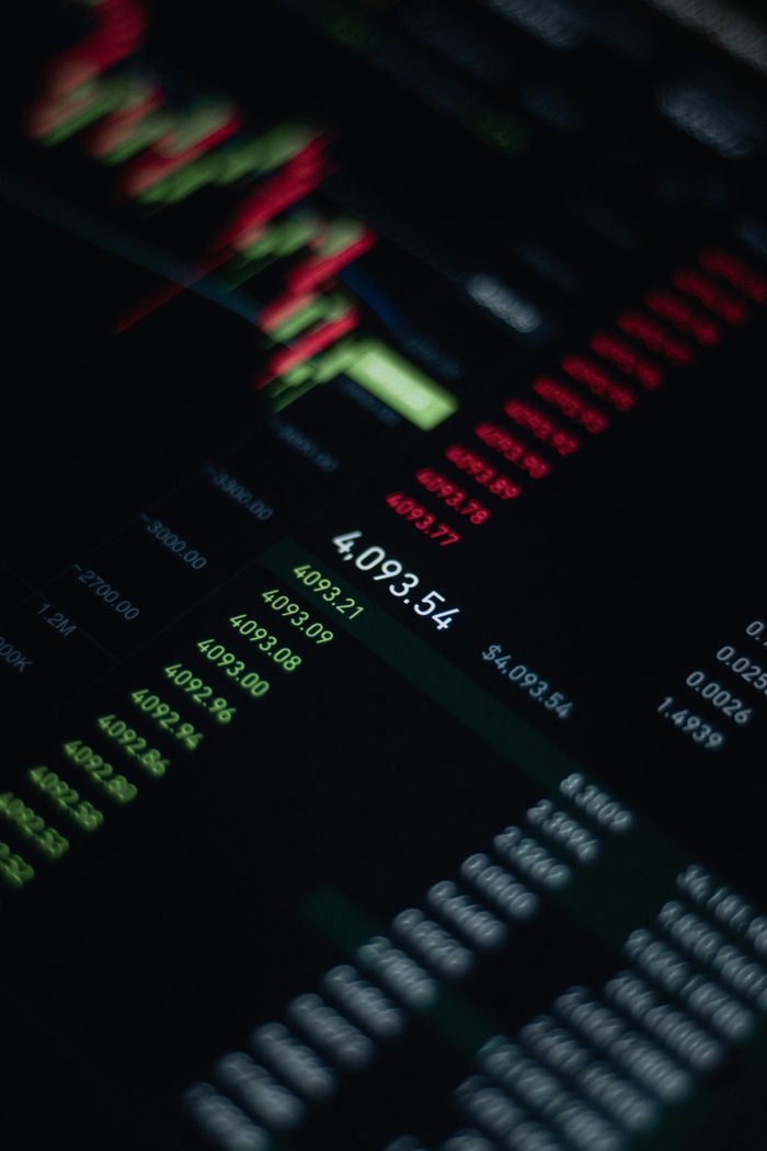 gallery-3 Close-up of stock market data with fluctuating numbers and graphs on screen.