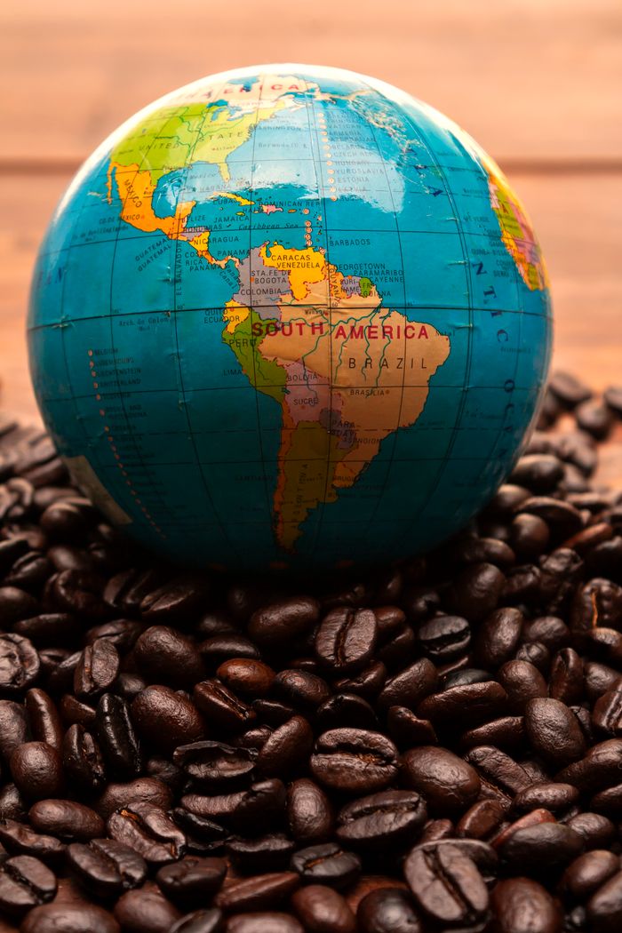 gallery-5 A globe on coffee beans highlighting South America's coffee origins.