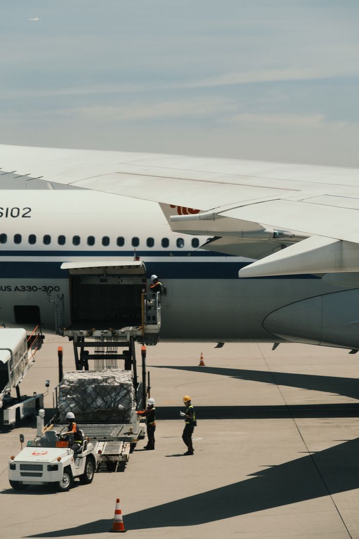 our-services-1 Airbus A330 being loaded with cargo on an airport runway, showcasing transportation logistics.