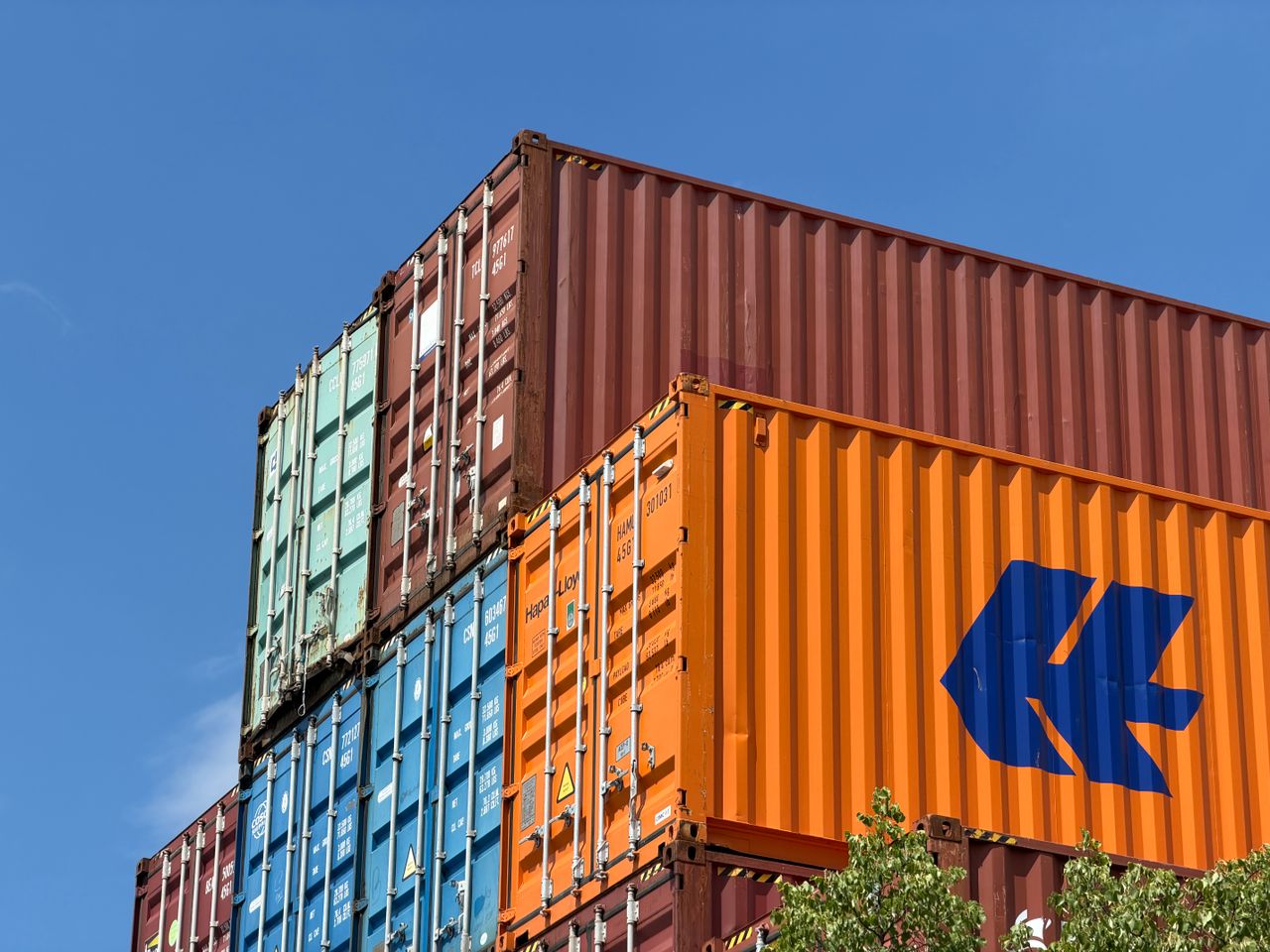 hero-img-01 Colorful shipping containers stacked in an outdoor storage area in Germany.