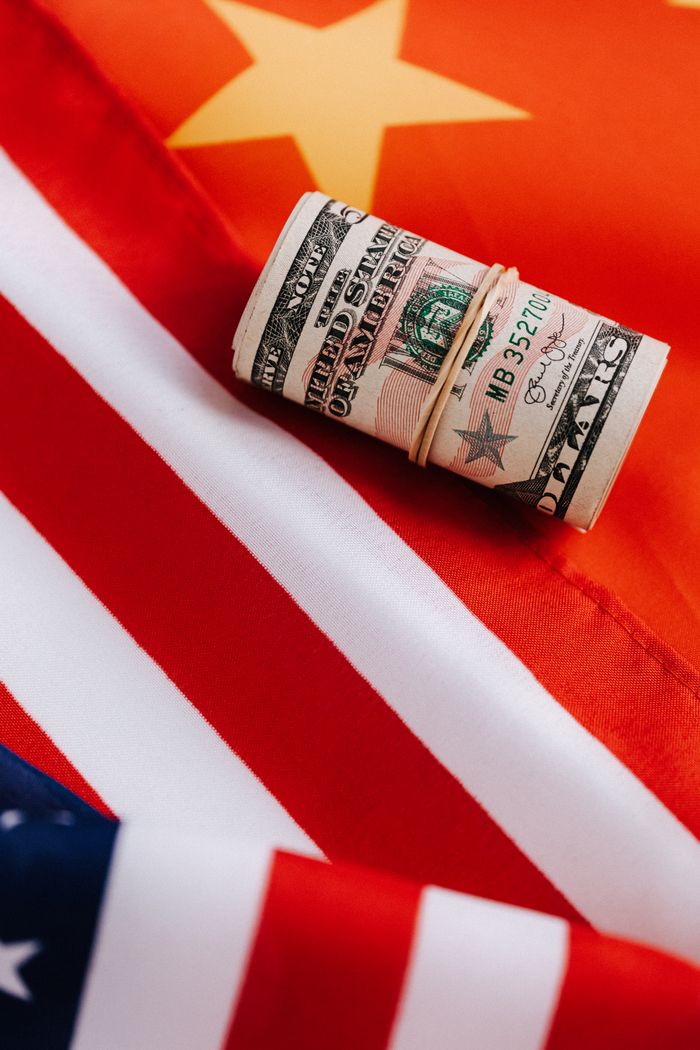 gallery-6 From above of colorful flag of United Stated of America with stripes and star near roll of dollar banknotes tied with rubber band